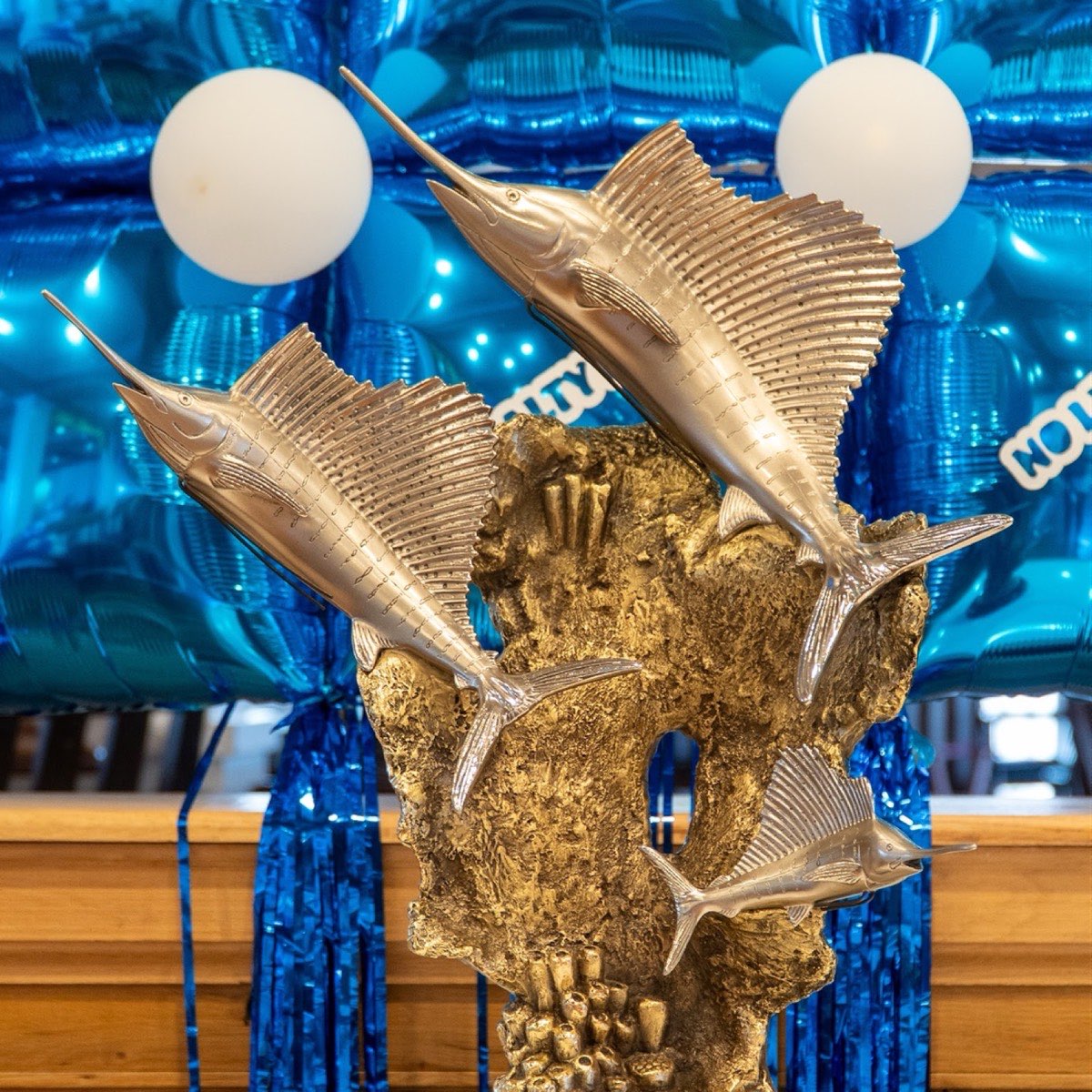 Sailfish tournament trophy in the clubhouse in front of blue balloon decorations
