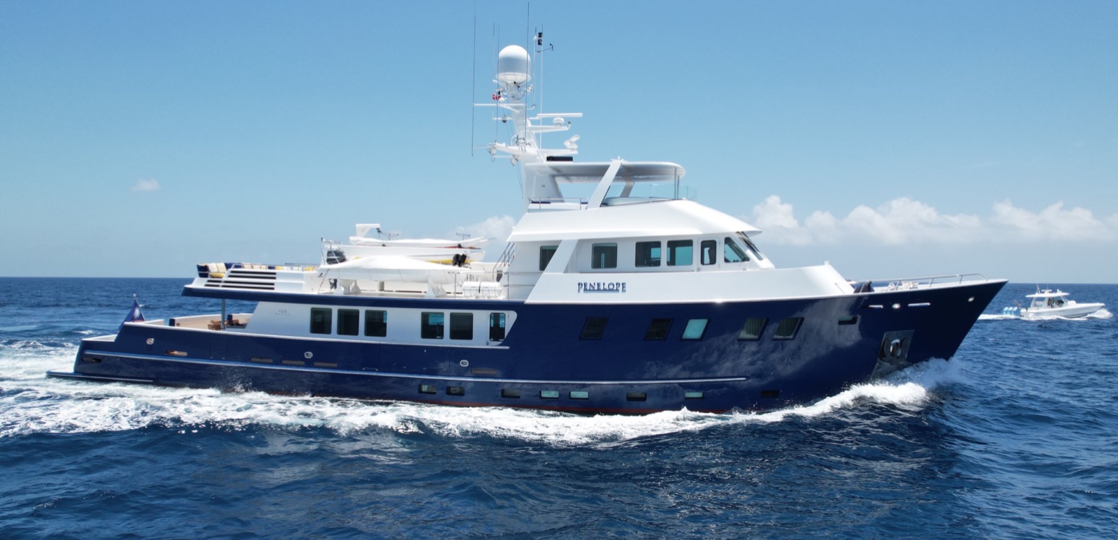The expedition yacht Penelope underway with a dark blue hull and white superstructure